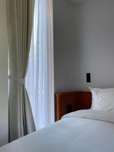 チェンマイにあるThe Sayla hotel(Baan Sayla)のベッドルーム(白いベッド1台、窓付)