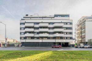 a large building with cars parked in a parking lot at Near Lake Stylish & Fully Furnished Apartment in Vienna