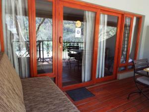 an open door to a deck with a dining room at Aloes Country Inn in Waterval Boven