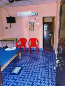 a room with two red chairs and a blue floor at Blue Bird Residency in Neil Island