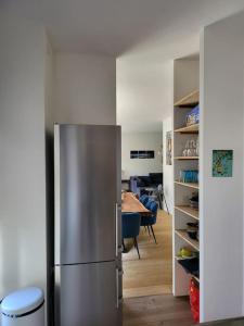 a kitchen with a stainless steel refrigerator in a room at Appartement luxe "La providence" , plein centre in Vichy