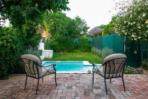2 sillas sentadas frente a una piscina en Garden House en Graaff-Reinet