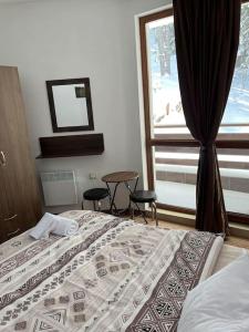 una camera con letto e finestra con sedie di Forest place a Pamporovo