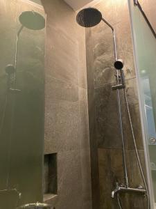 La salle de bains est pourvue d'une douche avec une porte en verre. dans l'établissement Solace Hotel, à Manille