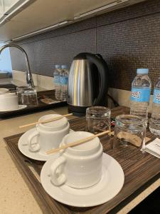 a kitchen counter with plates and cups and water bottles at Solace Hotel in Manila