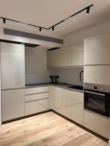 eine Küche mit weißen Schränken und Holzböden in der Unterkunft יחידת דיור סביון2 in Savyon