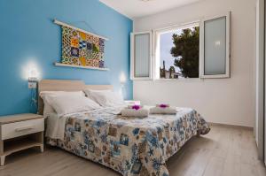 a bedroom with a bed with blue walls and two windows at Luxury Villa Urania with pool - Stella del Mare Fontanebianche in Fontane Bianche +87 photos