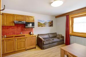 kuchnia i salon z kanapą w obiekcie Casa Marcos n 34 w Livigno