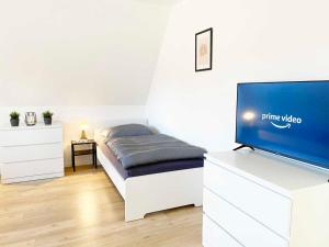 a bedroom with a bed and a flat screen tv at Spacious & Chic Apartment with Balcony in Ibbenbüren