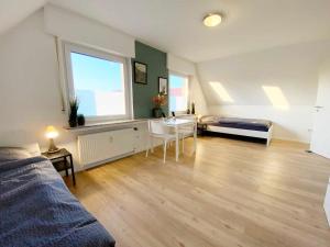 a living room with a bed and a table in it at Spacious & Chic Apartment with Balcony in Ibbenbüren