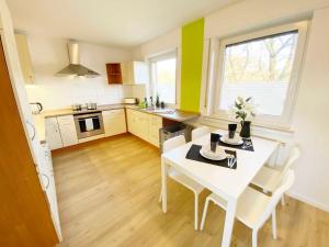 cocina con mesa blanca y sillas blancas en Spacious & Chic Apartment with Balcony en Ibbenbüren
