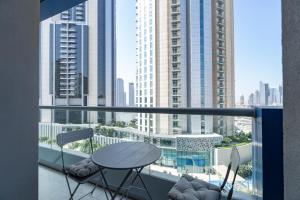 d'un balcon avec une table et des chaises offrant une vue sur la ville. dans l'établissement Deluxe 21st Flr Huge 3BR Pool & Gym Near Mall, à Dubaï