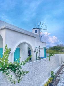 ein weißes Haus mit einer Windmühle darüber in der Unterkunft Anjo Maumere Hotel & Restaurant in Nangalima