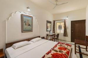 a bedroom with a large bed and a table at WelcomHeritage Kalyan Bhawan Hotel in Jaisalmer