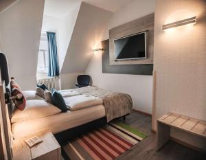 um quarto de hotel com uma cama e uma televisão de ecrã plano em Best Western Hotel Kurfürst Wilhelm I. em Kassel