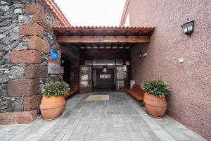 a building with two large pots with plants in it at Balneario Pozo de la Salud in Sabinosa