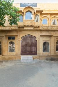 a building with a brown gate and a building with a sign at WelcomHeritage Kalyan Bhawan Hotel in Jaisalmer