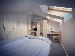 een witte slaapkamer met een bed en een bureau bij Da Vinci Guesthouse in Varshets