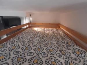 een kleine slaapkamer met een bed met een zwart-wit dekbed bij Studio Villard-de-Lans, 1 pièce, 4 personnes - FR-1-515-110 in Villard-de-Lans