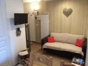 salon z kanapą i sercem na ścianie w obiekcie Charmant 2 Pièces Rénové 6 Pers, Balcon, Proche Pistes et Commerces - Morillon 1100 - FR-1-412-82 w mieście Morillon