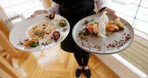 a person holding two plates of food in their hands at Narva-Jõesuu Medical Spa in Narva-Jõesuu