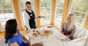 a waiter serving people at a table in a restaurant at Narva-Jõesuu Medical Spa in Narva-Jõesuu