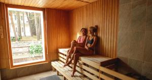 two women sitting on a bench in a sauna at Narva-Jõesuu Medical Spa in Narva-Jõesuu