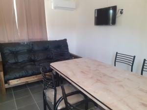 sala de estar con mesa y sofá de cuero en Posta Malbec en Las Compuertas