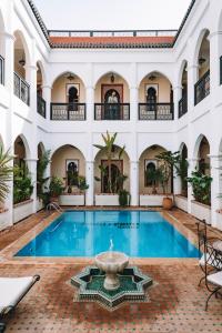 einen Pool in einem Gebäude mit einem Brunnen in der Unterkunft Equity Point Marrakech in Marrakesch