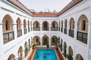 a large building with a pool of water in front of it at Equity Point Marrakech in Marrakesh