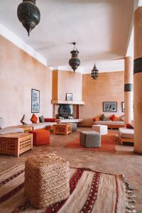 Equity Point Marrakech في مراكش: غرفة معيشة كبيرة مع كنب ومدفأة