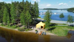 an island with a yellow tent next to a lake at Igloo Glamping LakeLand Camp in Imatra
