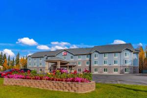 a large building with flowers in front of it at Best Western Plus Chena River Lodge in Fairbanks