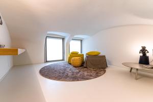 een woonkamer met een gele stoel en een tafel bij BnButler - Bergamo Città Alta - Appartamento di Charme in Bergamo
