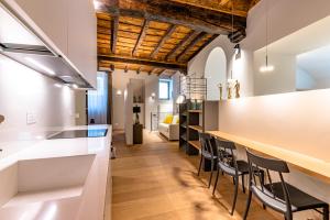 een keuken met witte werkbladen en zwarte stoelen bij BnButler - Bergamo Città Alta - Appartamento di Charme in Bergamo