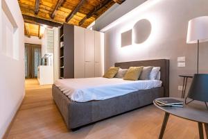 een slaapkamer met een groot bed en een tafel bij BnButler - Bergamo Città Alta - Appartamento di Charme in Bergamo