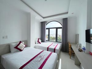 a hotel room with two beds and a window at Rubillion Hotel - 5-Min Walking to Back Beach in Vung Tau