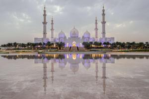 eine Moschee mit ihrem Spiegelbild im Wasser in der Unterkunft Andaz Capital Gate Abu Dhabi - a concept by Hyatt in Abu Dhabi