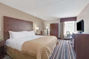 a hotel room with a bed and a flat screen tv at Wyndham Garden Charlotte Airport Southeast in Charlotte