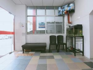 een kamer met 2 stoelen, een bank en een raam bij Kb Rest Inn-Deluxe Queen in Kota Bharu
