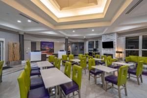 ein Restaurant mit Tischen und Stühlen und einem Flachbildfernseher in der Unterkunft La Quinta by Wyndham Birmingham Hoover in Hoover