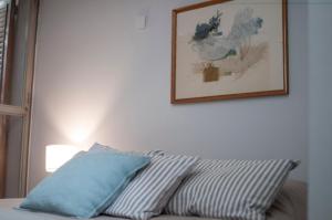 una almohada en la parte superior de un sofá con una foto en la pared en Casa Reconquista en Mendoza