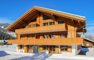 a large wooden building with snow in front of it at Ferienwohnung Bärtschi in Lenk