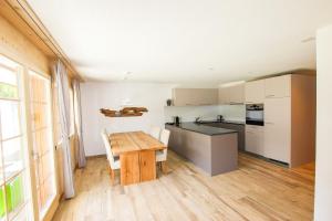 a kitchen with a wooden table and a wooden floor at Ferienwohnung Bärtschi in Lenk