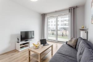 a living room with a couch and a table with a laptop at Chill Apartments Mokotów Business Center in Warsaw