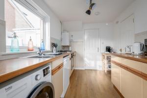 a kitchen with a washer and dryer in it at Letham Place - 3 Bedroom House - Sleeps 5 - Log Burner in Fife