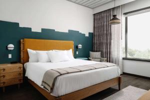 um quarto com uma cama grande e uma janela grande em Origin Austin, a Wyndham Hotel em Austin