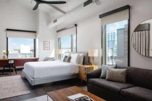 a bedroom with a bed and a living room with a couch at Origin Austin, a Wyndham Hotel in Austin