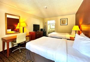 a hotel room with two beds and a desk and a mirror at Econo Lodge in Bossier City