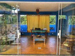 uma sala de estar com uma mesa e uma cortina amarela em Pousada Trilha do Sol em Pirenópolis